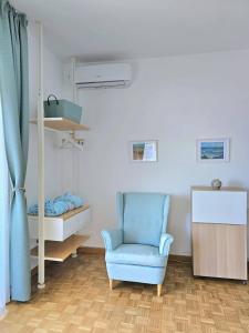 Cette chambre comprend une chaise bleue et un lit. dans l'établissement La Stella dei Venti B&B, à Naples