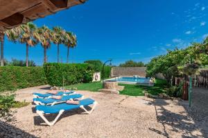 a group of blue lounge chairs sitting next to a pool at Villa Can Guaita II in El Port