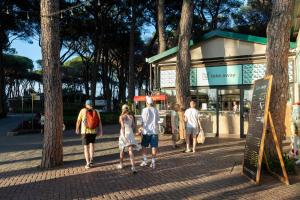 a group of people walking down a sidewalk at Fabulous village in Casal Palocco