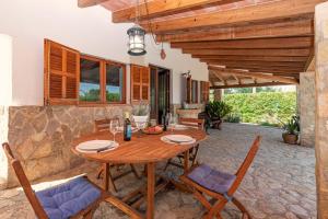 a dining room with a wooden table and chairs at Villa Can Guaita II in El Port