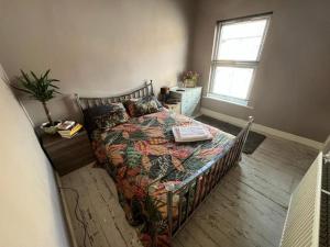 a bedroom with a bed with a comforter and a window at Charming newly renovated terrace in Liverpool