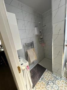 a small bathroom with a shower and a sink at Charming newly renovated terrace in Liverpool