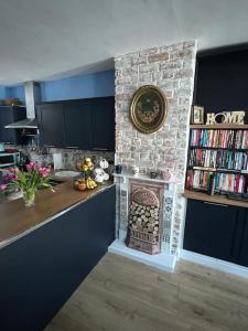 a kitchen with a stone wall with a fireplace at Charming newly renovated terrace in Liverpool