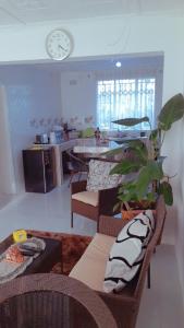 a living room with chairs and a clock on the wall at KMK APARTMENTS in Kitwe