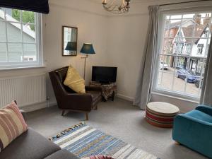 uma sala de estar com uma cadeira e uma televisão em House On The Hill em Framlingham