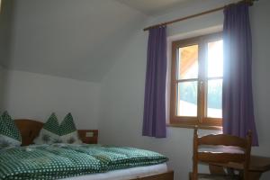 a bedroom with a bed and a window with purple curtains at Haus Hödlmoser in St. Wolfgang