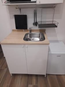 a kitchen with white cabinets and a sink at Il Fondaco all'Archivio Storico in Naples