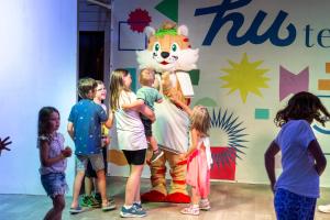 a group of children looking at a tiger mascot at Fabulous village in Casal Palocco