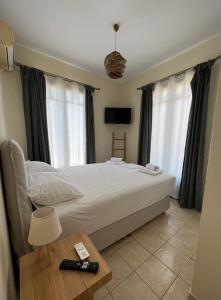 Anoixi Apartments في Korissia: غرفة نوم بسرير كبير وطاولة