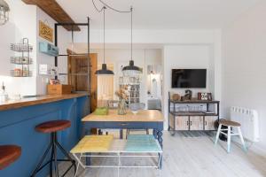 cocina con mesa y taburetes en una habitación en Astoria - baskeyrentals en San Sebastián