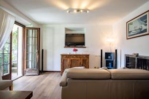 a living room with a couch and a flat screen tv at Sailor House Near Lake in Pianello Del Lario