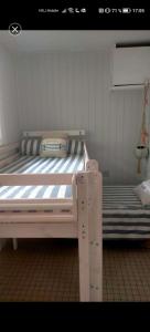 1 Schlafzimmer mit einem weißen Bett und 2 Etagenbetten in der Unterkunft Le petit paradis iodé in Gujan-Mestras