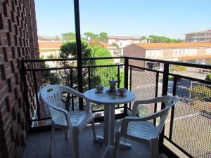 een tafel en 2 stoelen op een balkon met een tafel bij Appartamento Xibana in Bibione +3 foto's