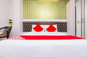 1 dormitorio con 1 cama grande con almohadas rojas en OYO Hotel Sehej Continental, en Nueva Delhi
