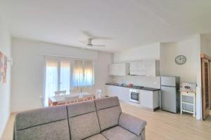 a living room with a couch and a table and a kitchen at S.Benedetto Terrace apartment in Peschiera del Garda