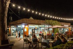 a group of people sitting at a restaurant at night at Fabulous village in Casal Palocco