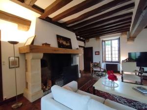 a living room with a white couch and a fireplace at Domaine de l'Ormerie Provins in Provins