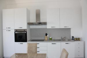 een witte keuken met witte kasten en een wastafel bij La Mia Villa in Ceglie Messapica
