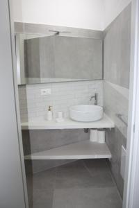 W białej łazience znajduje się umywalka i lustro. w obiekcie La Mia Villa w mieście Ceglie Messapica