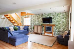 a living room with two blue couches and a fireplace at Elm Escapes in Knighton