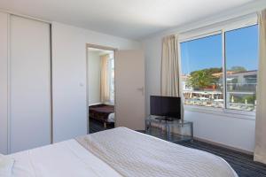 a bedroom with a bed and a television and a window at Duplex à La Marina in Saint-Raphaël