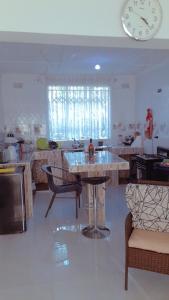 a kitchen with a table and a clock on the wall at KMK APARTMENTS in Kitwe