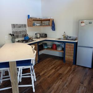 a kitchen with a table and a refrigerator at Let the good times roll-with inverter and wifi in Cape St Francis