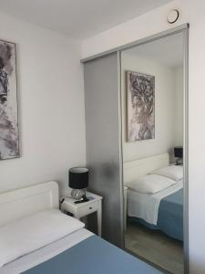 1 Schlafzimmer mit 2 Betten und einem Spiegel in der Unterkunft Apartman Rabatin in Sveti Filip i Jakov