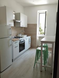 cocina con electrodomésticos blancos, mesa y ventana en MI CASA TU CASA en Civitavecchia