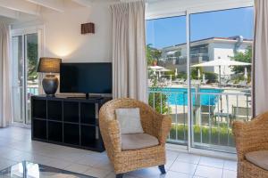 a living room with a tv and chairs and a balcony at Duplex à La Marina in Saint-Raphaël +5 photos