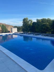 une grande piscine d'eau bleue et des bancs dans l'établissement Quinta Estrela d'Alva, à Alcobaça