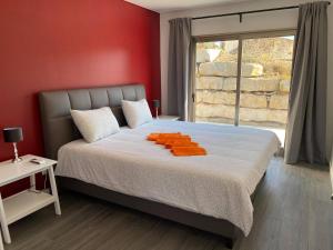 a bedroom with a bed with orange pillows on it at Quinta Estrela d'Alva in Alcobaça