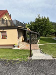 uma casa com um alpendre e uma varanda em Apartma Zeleni Raj em Ptuj