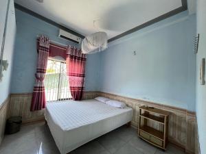 a small bedroom with a bed and a window at Trang Vu Homestay Cu Lao Cham in Tân Hiệp