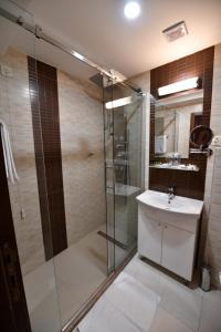 a bathroom with a glass shower and a sink at Hotel Beograd in Čačak