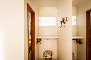 a hallway with a mirror and a chair at Suites em Jabaquara, Paraty in Paraty