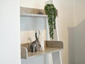 a shelf with two birds on it with a plant at St Johns House in Burnley
