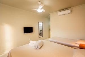 Habitación de hotel con 2 camas y TV en Suites em Jabaquara, Paraty, en Paraty