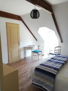 1 dormitorio con 1 cama, mesa y sillas en Chambres d'Hôtes des Hirondelles, en Beaussais sur Mer