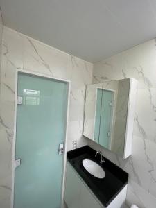 y baño con lavabo y espejo. en A Jóia de Blumenau Home Office e Garagem Coberta, en Blumenau