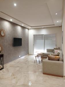 uma sala de estar com um sofá e uma mesa em Casabay appartement pied dans l'eau 87 m2 em Sidi Rahal