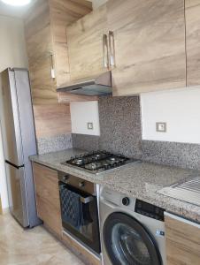 a kitchen with a washing machine and a refrigerator at Casabay appartement 87 m2 très proche de la plage in Sidi Rahal