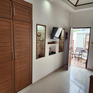 Habitación con armario de madera y TV en la pared. en Bungalows Musch Kamala Phuket, en Kamala Beach