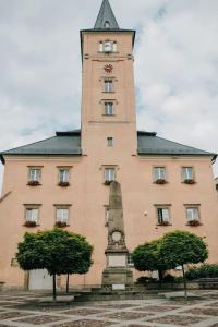 a tall building with a clock tower in front of it at Apartament Komnata in Radków