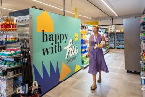 a woman walking through a store aisle with a happy with hub sign at Fabulous village in Casal Palocco