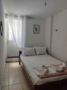 a bedroom with a bed with two towels on it at CORFU FOTIS house in Neochorákion