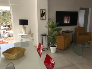 sala de estar con mesa y TV en Campagne luxueuse de Sitges, en Olivella