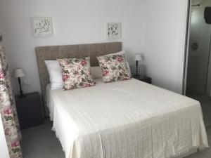 a bedroom with a white bed with two pillows at Campagne luxueuse de Sitges in Olivella