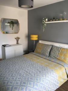 1 dormitorio con cama y espejo en Comfortable rooms with live in host, walking distance to the High St & more en Glastonbury