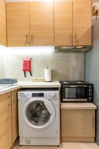 a kitchen with a washing machine and a microwave at Lion's Cave suite No 1. in Kalamata